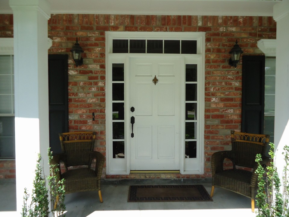 inviting front porch. entry door offers side and top glass transoms.